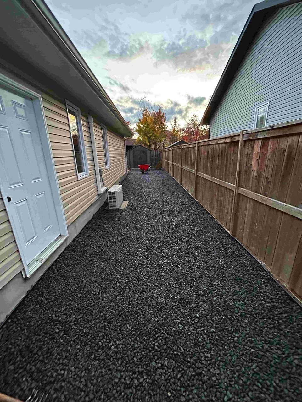 Finished gravel walkway along the side of a house
