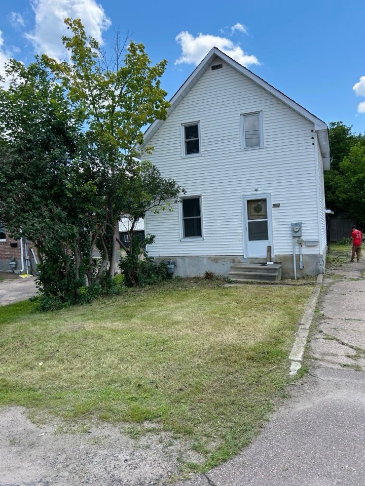 Crew trimming brush along a property line